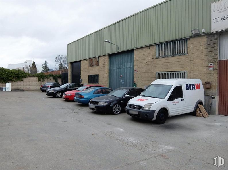 Industrial for sale at Polígono P-29, Collado Villalba, Madrid, 28400 with car, van, tire, wheel, automotive parking light, vehicle, sky, building, motor vehicle and cloud around