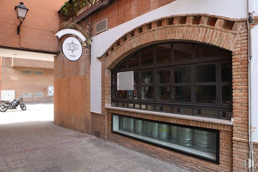 Retail for sale at Calle Vía Complutense, Alcalá de Henares, Madrid, 28805 with clock, motorcycle, tire, brickwork, brick, wheel, window, building, wall and facade around